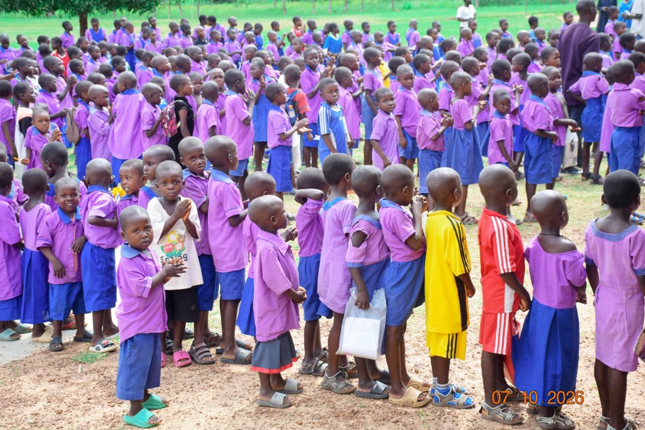 Pupils in purple checked uniforms clapping and cheering