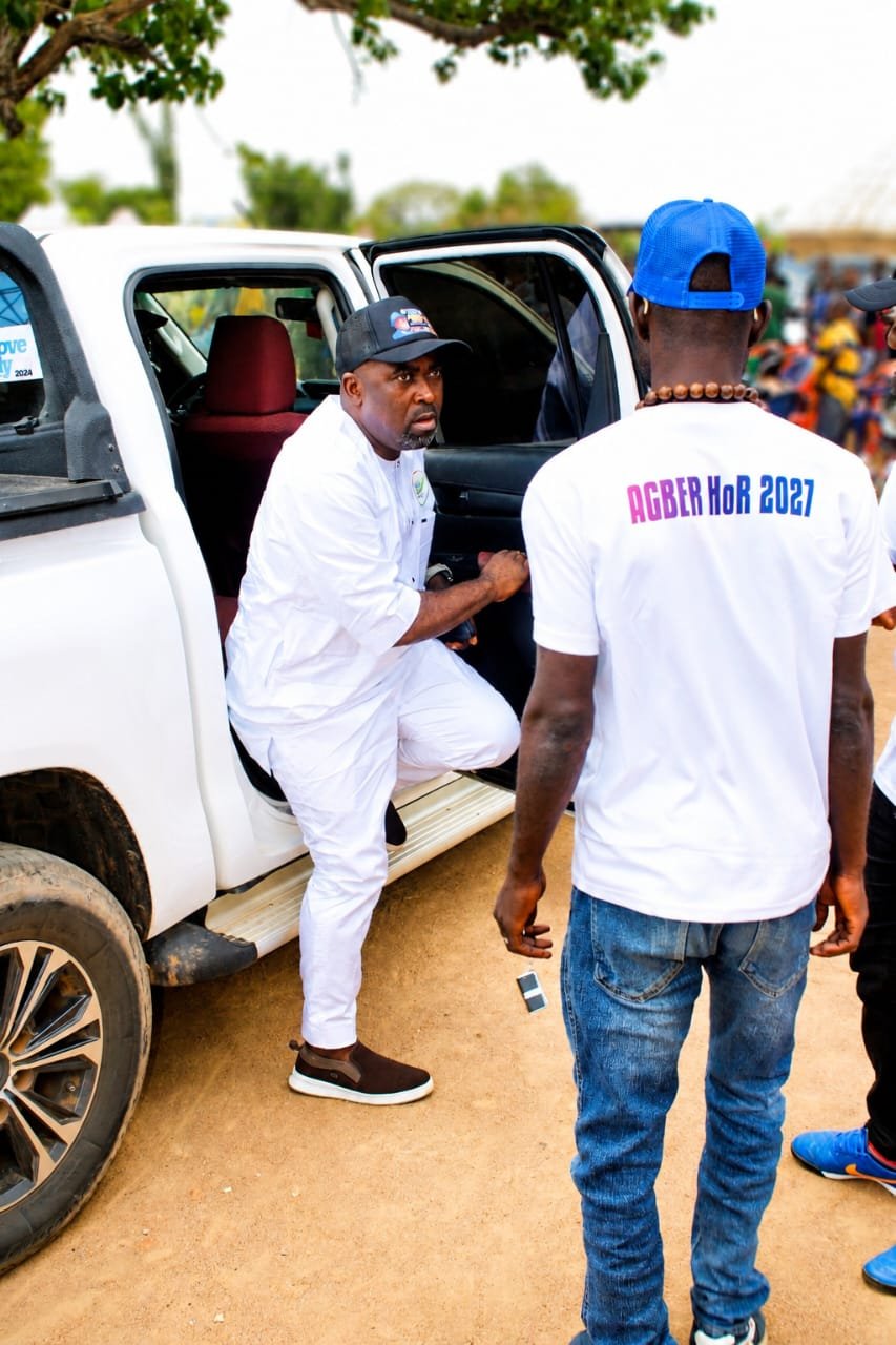 Agber, dressed in white, stepping out of a white vehicle for a constituency engagement
