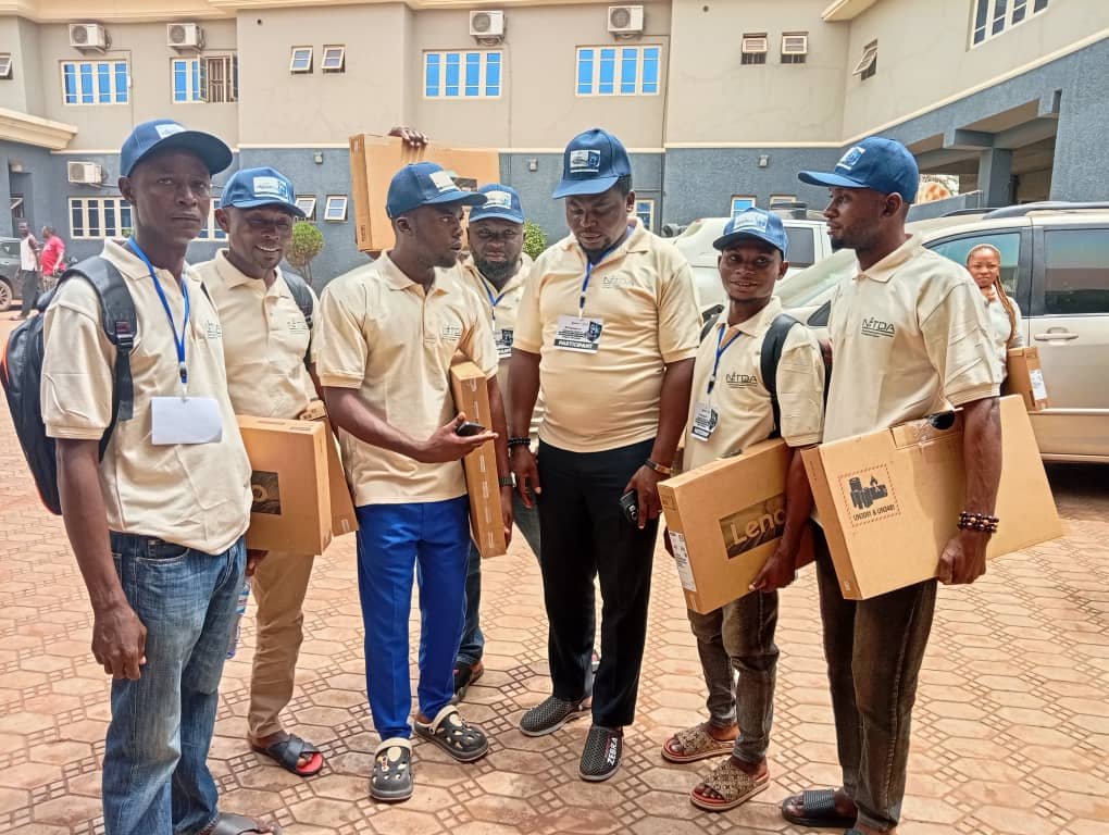 A smaller group of beneficiaries in cream polo shirts with their laptops