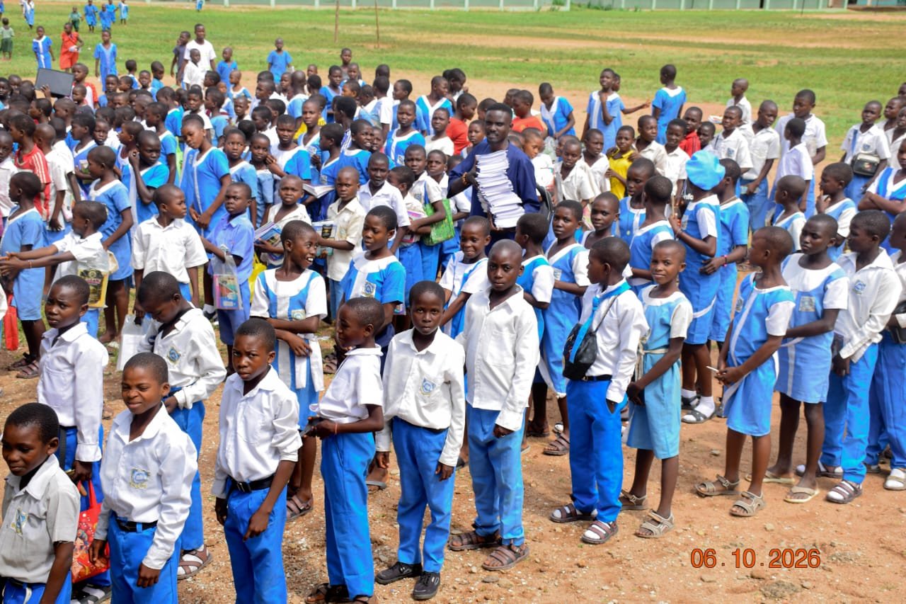 Rows of pupils in blue and white uniforms at a school compound in Mbaakura